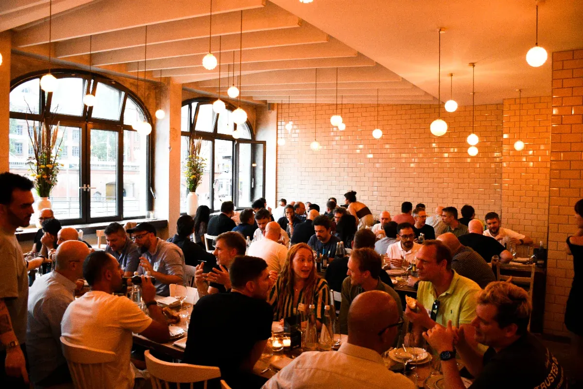 A crowded CTO dinner in a tiled dining room